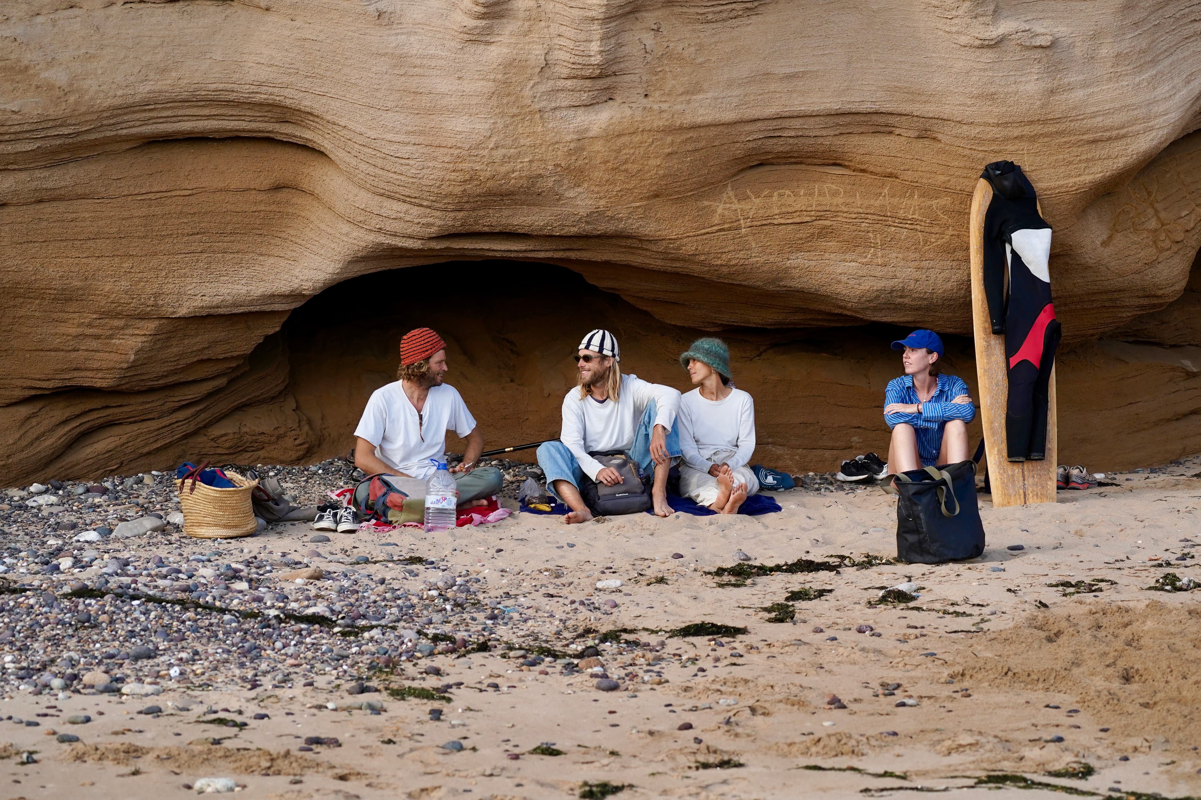A small group sitting together under the rocks after a session